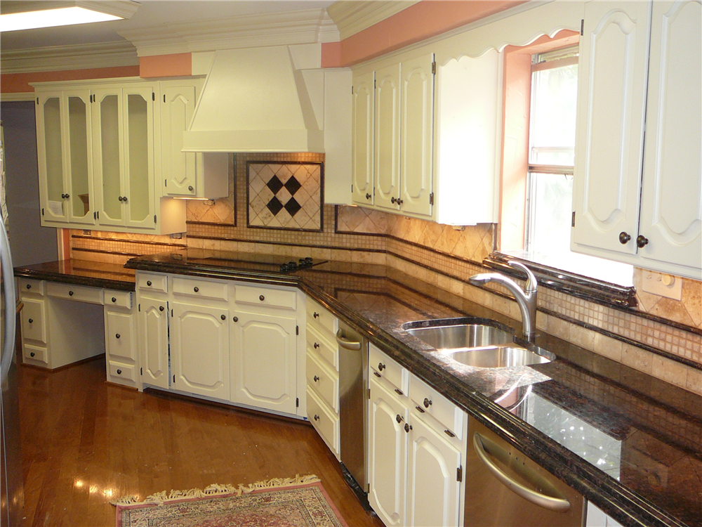 After client remodeled her floors with us and updated her paints and texture, she asked to make a special Granite with laminated edging. It is a demi over ogee edge. The granite pulls in the coral colors (her favorite!) and coordinates nicely in person! Tumbled stone and granite backsplash. Fort Worth, TX